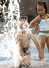Children play in a fountain on a hot Wednesday afternoon in Tokyo