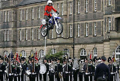 A member of the Imps Motorcycle display team jumps over the Guard of His Majesty The King of Norway Band and Drill team during a rehearsal for the Edinburgh Military Tattoo at the Redford Barracks, Edinburgh, on Wednesday