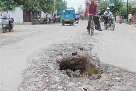 A deep hole in a road in front of BCM Model School in Ludhiana on Friday