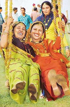 SAWAN KE JHULE: These young girls have fun on a flower-bedecked swing during the Teej utsav at Haryana Raj Bhavan in Chandigarh