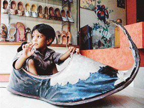 A Patiala shoemaker claims this to be the worlds biggest Punjabi jutti. However, a child playfully rocks it like a boat at a jutti store near Topkhana Bazar at Patiala. 