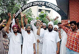 Relatives and residents of Bibipur village protest against the alleged police inaction in front of Govt Rajindra Hospital, Patiala, on Monday. The bodies of two persons killed were placed in the hospital mortuary.
