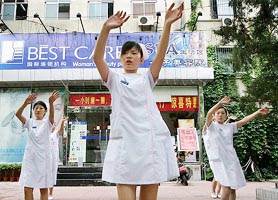 Chinese employees dance to modern music outside a beauty parlour before the start of work in Beijing on Monday. 