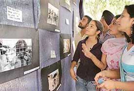 Students take a round of the photo exhibition featuring frames clicked by slum children of the city at  Panjab Universitys English Department on Tuesday.