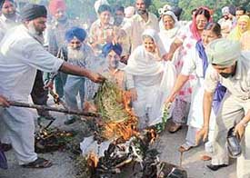 Members of various Sikh organisations burn an effigy of the Nanavati Commissions Action Taken Report at Sector-17 in Chandigarh on Tuesday.