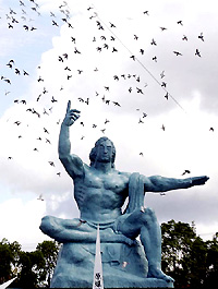 Doves flutter around the Peace Statue in Nagasakis Peace Park in Nagasaki