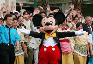 Disney character Mickey Mouse shows the welcome sign with other Disney staff members after a press tour to Hong Kong Disneyland hotel on Tuesday. 