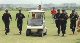 Chief Minister Bhupinder Singh Hooda drives through the greens of Panchkula Golf Club, as his securitymen try to keep pace on Wednesday.