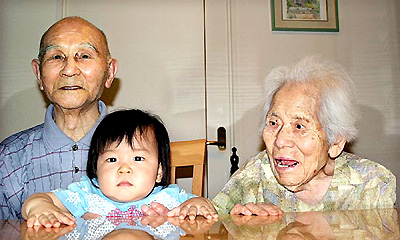 Yoichi Gomi, 104 years old, and his 103-year-old wife, Kazono, who plan to claim the title of the world's oldest married couple pose for a picture with their great-grandson Seiya