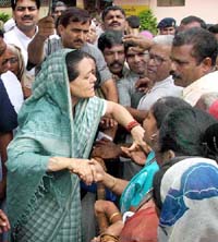 Congress President Sonia Gandhi interacts with flood victims at Narsingwad in Kolhapur district during her visit to Maharashtra