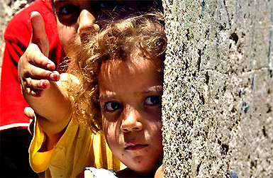 Palestinian refugees look outside their home in a Gaza camp in north of Amman on Saturday
