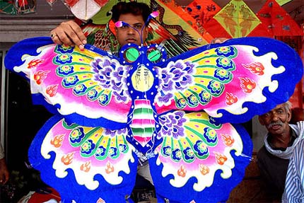 A shopkeeper displays a Chinese kite in New Delhi