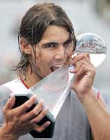 Rafael Nadal of Spain bites into the trophy after beating Andre Agassi of the USA in the final of the Rogers Cup in Montreal
