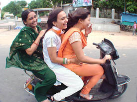 College girls wearing a combination of the Tricolour drive on a road in Ahmedabad on Tuesday. 