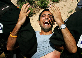 A Jewish settler screams, as he is carried by the Israeli police in the Neve Dekalim settlement in the southern Gaza Strip on Tuesday