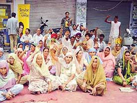 Residents of Purana Bhangala village on dharna in front of the Mukerian police station in protest against the illegal confinement of a youth of their village in a murder case.