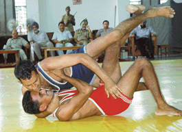Krishan Kumar (top) of 134 Battalion on his way to win 55 kg bout in the inter-battalion wrestling championship at Sector 42, Chandigarh, on Thursday.