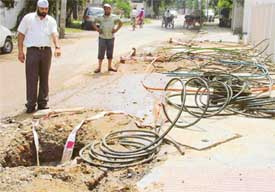 Open pits on roads in Model Town where a telecom company is laying cables