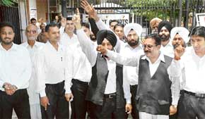 Lawyers protest outside the District Courts in protest against the registration of case against two advocates in Chandigarh on Friday.