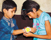 A girl tying a rakhi on the wrist of her brother on the occasion of Raksha Bandhan on Friday.