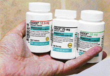 A pharmacist holds bottles of prescription arthritis and pain medication Vioxx in this file picture. A jury in the first civil trial against Merck & Co.s popular painkiller Vioxx on Friday found the pharmaceutical company liable for the 2001 death of a Texas man, awarding his widow $253.4 million as damages.
