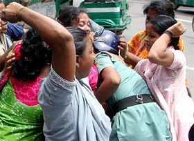 Activists from the Opposition party confront a police personnel during a strike in Dhaka