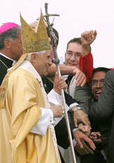 People take pictures of Pope Benedict as he leaves a mass during the 20th World Youth Day at Marienfeld, a former coal mine, near the West German city of Cologne on Sunday.