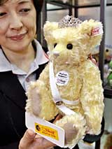 An employee of Japanese toy giant, Takara, displays a teddy bear with a tiara, called Princess Teddy, produced by German teddy bear maker Margarete Steiff on Monday in Tokyo. The teddy bear, produced for the celebration of the wedding of Japanese Princess Sayako in November, will go on sale in October with a price tage of 38,000 yen ($ 345). 