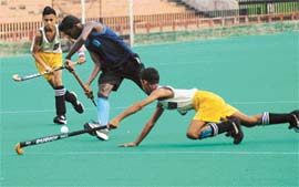 Beant Singh, defender of Dashmesh Hawks Academy, Ropar, jumps to stop forward player of DAV School, Chandigarh, during 4th S.N. Vohra Memorial Sub Junior (u-14) Hockey Tournament at Sec-42, Chandigarh, on Monday.