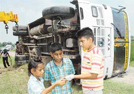 Students of Lala Deep Chand Jain Public School, Mehmoodpura, show injures they sustained when their school bus fell into a paddy field in Bahura village, about 5 km from Dera Bassi, on Monday morning. Over dozen students were injured in the accident.