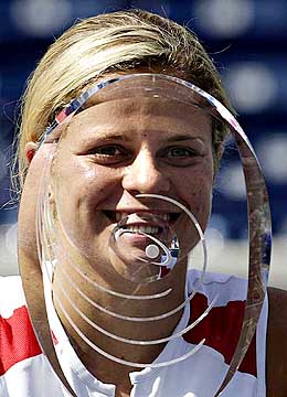 Kim Clijsters of Belgium looks through the trophy after defeating compatriot Justine Henin-Hardenne in the final of the Rogers Cup 