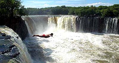 Di Huanran, a Chinese, jumps from a waterfall into Jingbo Lake at Mudanjiang city in northeast China's Heilongjiang province, on Sunday