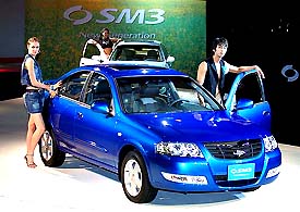Models pose with an SM3 New Generation of Renault Samsung Motors during a press unveiling in Seoul on Tuesday