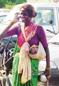 A beggar with her child in scorching heat to get alms. 