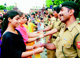 Students of local colleges tie rakhis on the wrists of jawans on the ocassion of Raksha Bandhan 