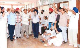 Residents of Shaheed Bhagat Singh Nagar sit on a dharna outside the office of the LIT Chairman to protest against lack of civic amenities in their area, in Ludhiana