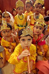 Children dressed as Lord Krishna wait to perform in their school during festivities marking Janmashtami in New Delhi