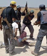 Israeli security guards scuffle with a Palestinian demonstrator at the construction site for Israels controversial barrier during a protest in the West Bank village of Ramadin near Hebron 
