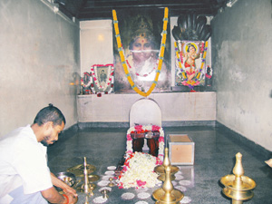 A devotee performs puja at the darshan temple