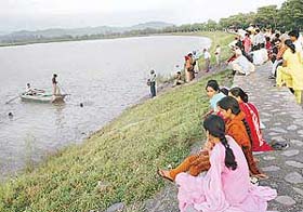 Visitors to the Sukhna Lake look on as the divers of the Chandigarh police search for two-and-a-half-year-old Manpreet Kaurs body