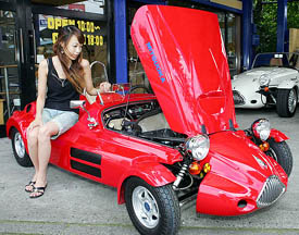 An employee of Japan's Mitsuoka Motor Corp displays the company's one-seater convertible sports car "Micro Type-F" at its showroom in Saitama, north of Tokyo
