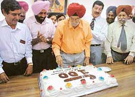 Tarlochan Singh Bawa, who was a member of Indias Olympic gold medal winning hockey team in 1948, cuts the cake on the eve of the 100th birth anniversary of hockey wizard Dhyan Chand 
