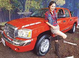 A South Korean model poses next to DaimlerChryslers new sports utility truck Dodge Dakota 