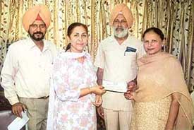 Prof Kulwant Singh (second from right) is given a cheque for Rs 5 lakh by Ms Raghbir Kaur Khaira in Ropar on Tuesday. 