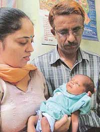 Pooja nestled in the arms of her foster parents. 