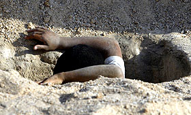 An Iraqi youth digs a grave to burry victims killed in Baghdad stampede