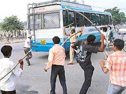 Arsonists run after a bus with lathis in Sector 17, Panchkula, on Friday.