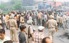 Policemen try to disperse a mob that blocked traffic at Cheema Chowk on Saturday afternoon in protest against the Gohana incident