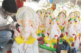 Preparing for Ganesh Chaturthi: An artisan gives finishing touches to Ganesha idols