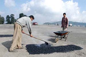 Workers of the Public Works Department give a facelift to the helipad near Chhrabra, 15 km from Shimla